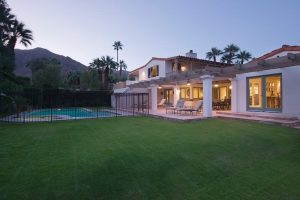 Luxury home backyard with pool, patio furniture, and mountain views at dusk. Palm Springs real estate.