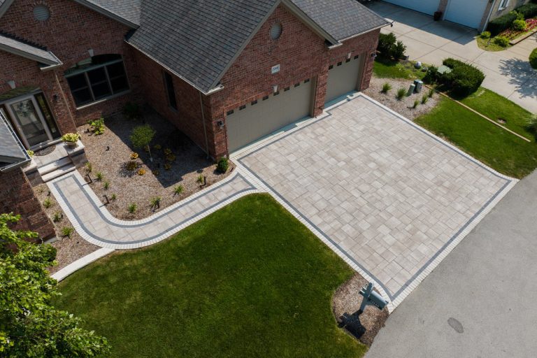 Aerial photo of a house with a brick paver driveway and walkway