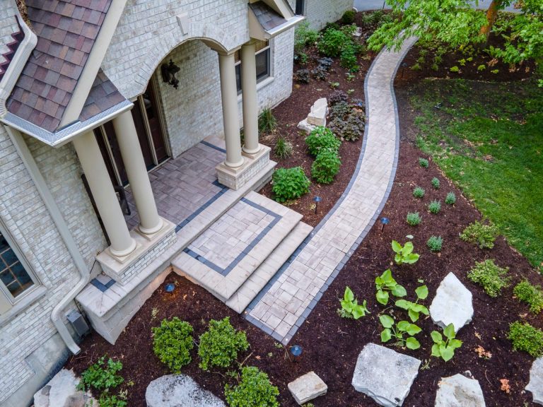Aerial view of home with stone landscaping, walkway, and manicured lawn. Oswego, IL landscaping design.