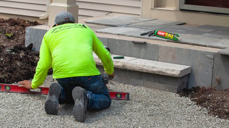 Residential landscape design installation. Landscaper installing stone steps for home. Commercial landscaping.