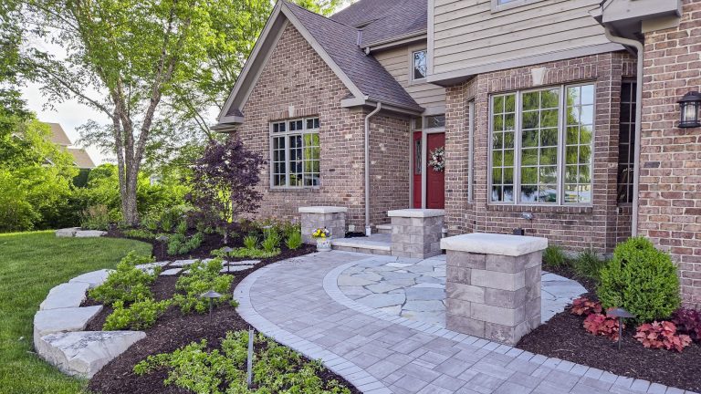 Brick paver walkway landscaping with plantings leading to a brick home. Curb appeal.