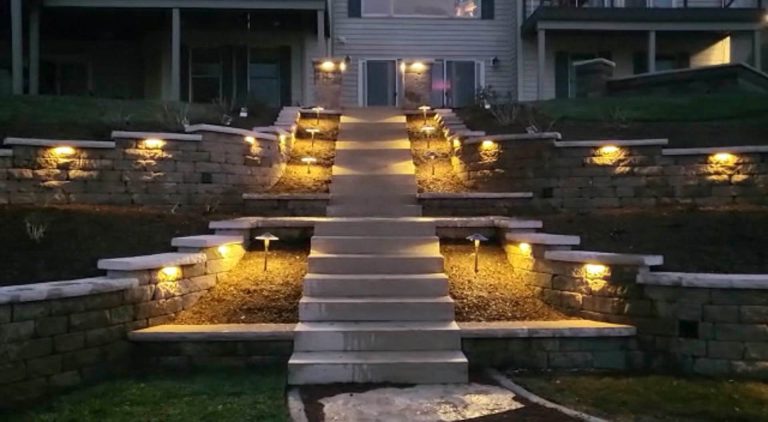 Backyard illumination with landscape lighting on retaining walls and steps. Commercial landscaping.