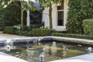 Outdoor water feature with fountains in a garden setting. Landscape design.